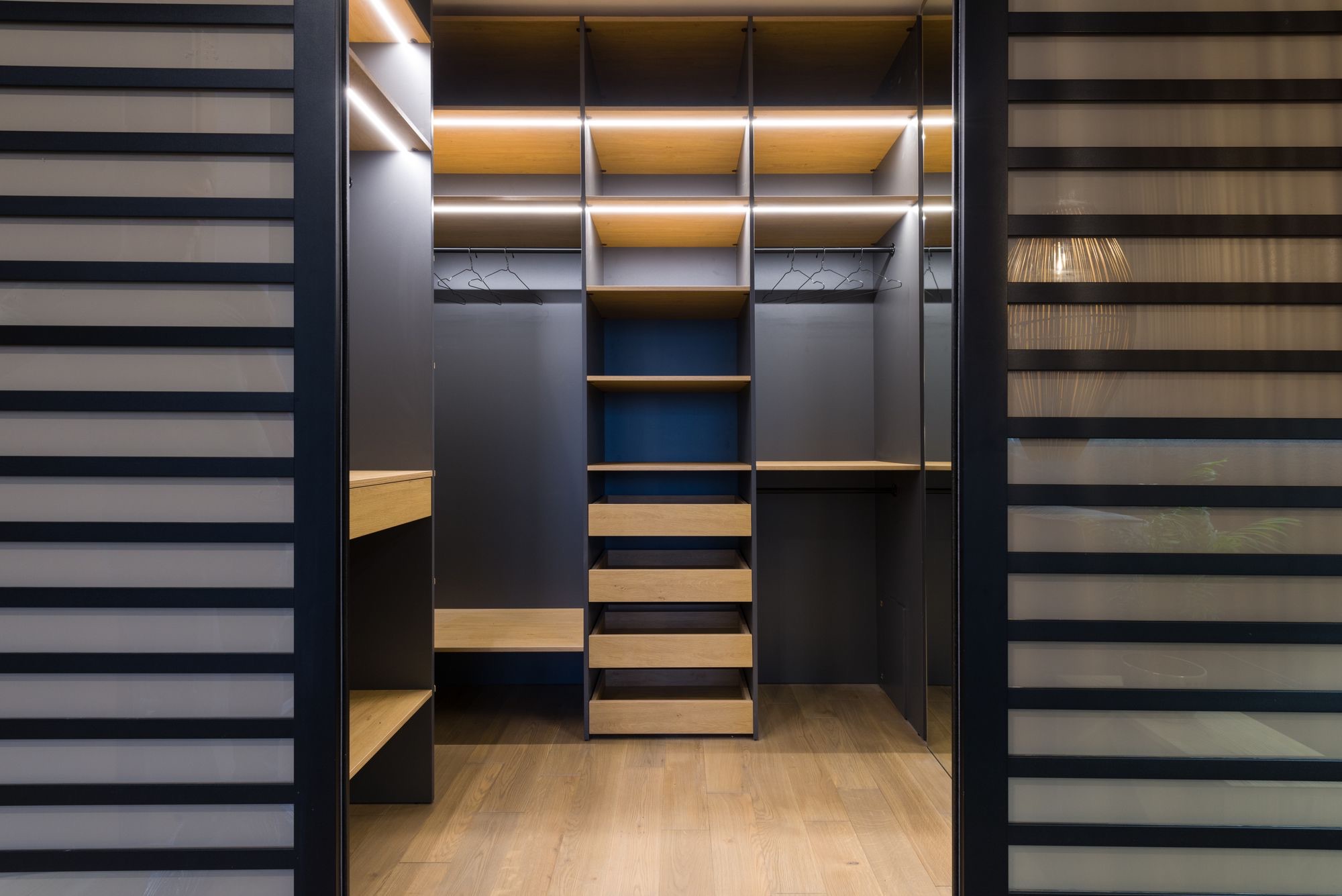 Charcoal walk-in closet with LED-lit shelving
